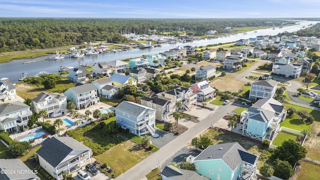 birds eye view of property featuring a water view and a view of trees