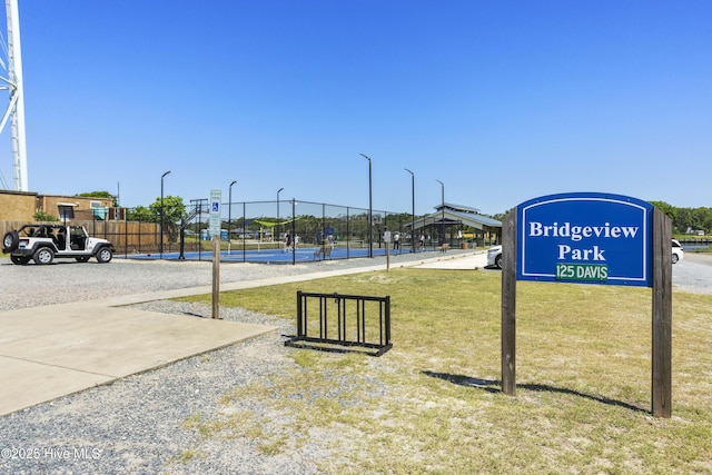 view of property's community with a lawn and fence