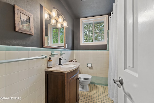 bathroom with vanity, toilet, tile walls, and curtained shower