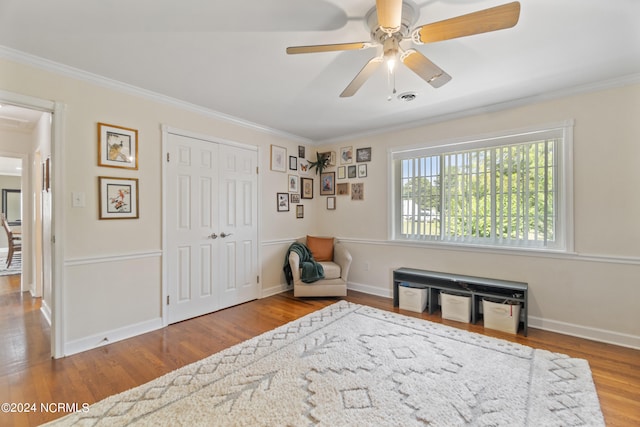 sitting room featuring ornamental molding, wood-type flooring, and ceiling fan