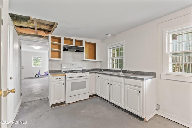 kitchen featuring white range with gas stovetop, sink, white cabinetry, and a wealth of natural light