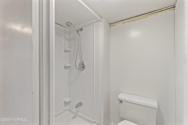 bathroom featuring toilet and tiled shower