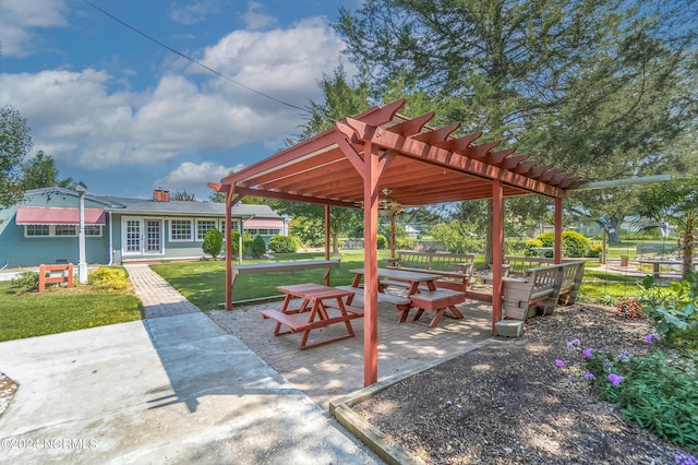 view of property's community with a patio, a lawn, and a pergola