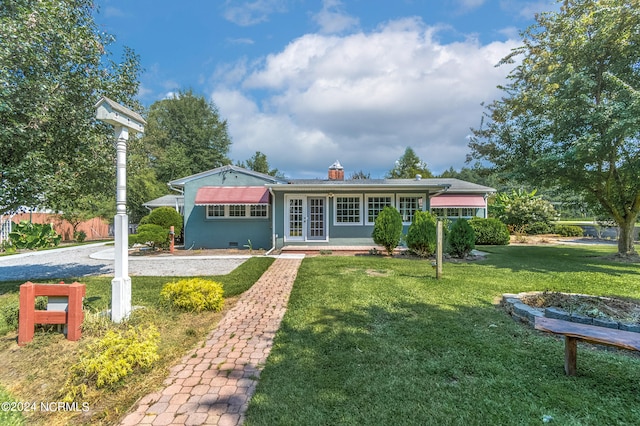 single story home with french doors and a front lawn