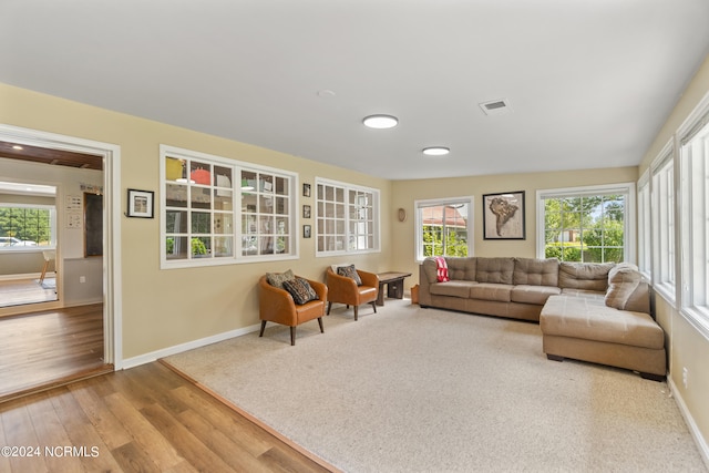 living room with a healthy amount of sunlight, wood-type flooring, and vaulted ceiling