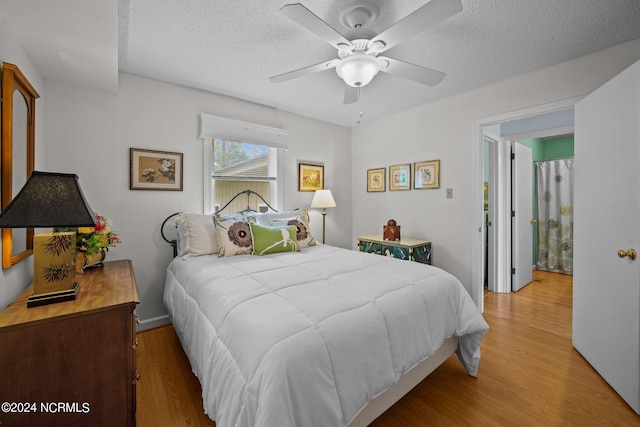 bedroom featuring a ceiling fan, light wood-style flooring, and a textured ceiling