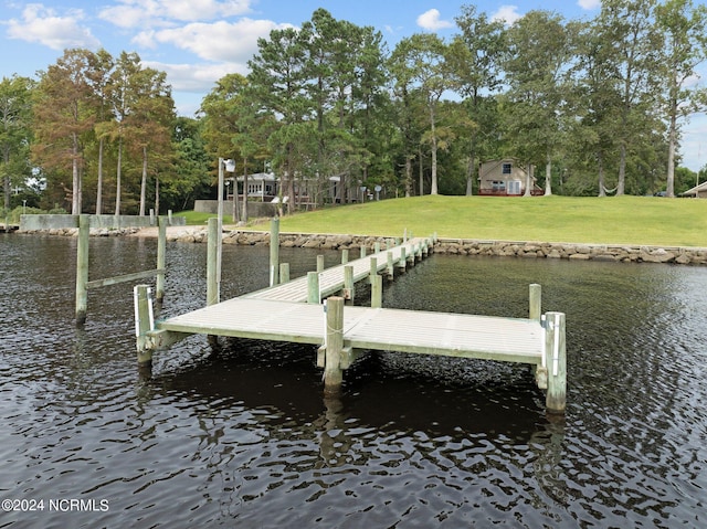 view of dock featuring a water view and a yard