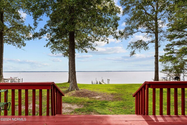 wooden deck featuring a water view and a yard