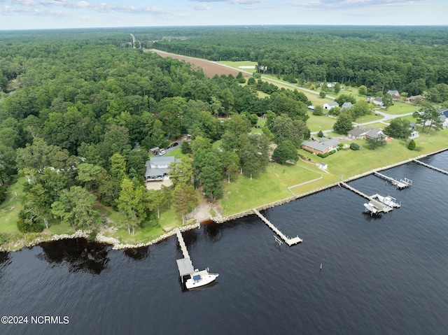 birds eye view of property featuring a water view and a wooded view