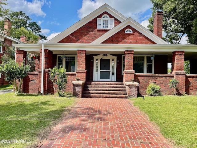 view of front of home with covered porch and a front yard