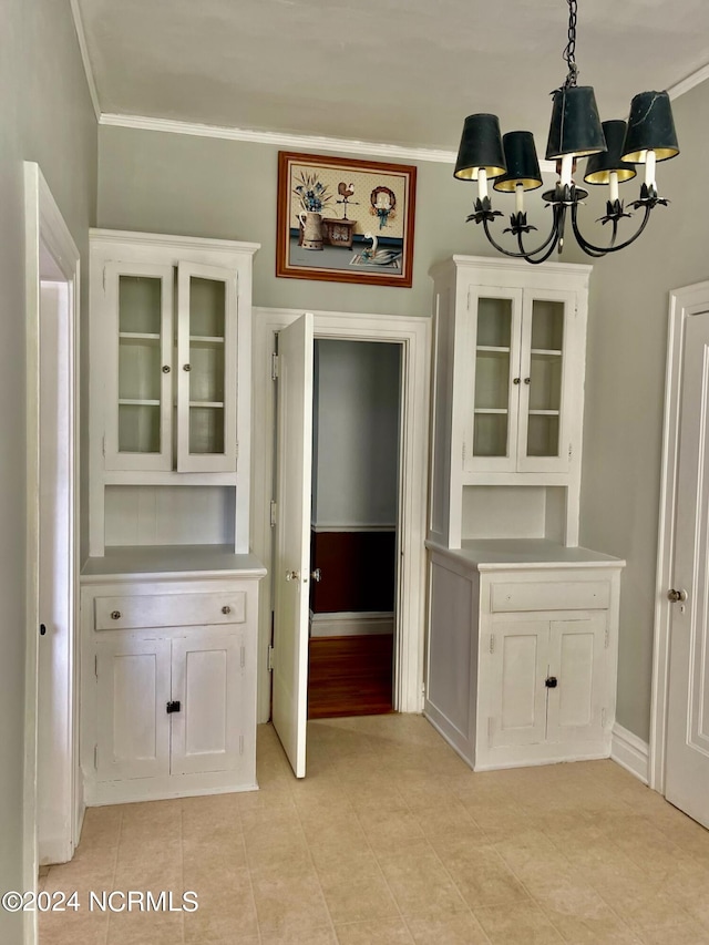 unfurnished dining area featuring ornamental molding and a notable chandelier