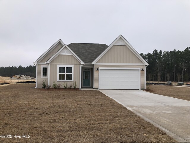 view of front facade featuring a garage, a shingled roof, stone siding, driveway, and a front lawn