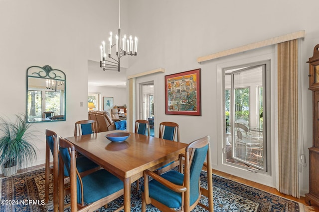 dining space featuring a notable chandelier, a high ceiling, and hardwood / wood-style flooring