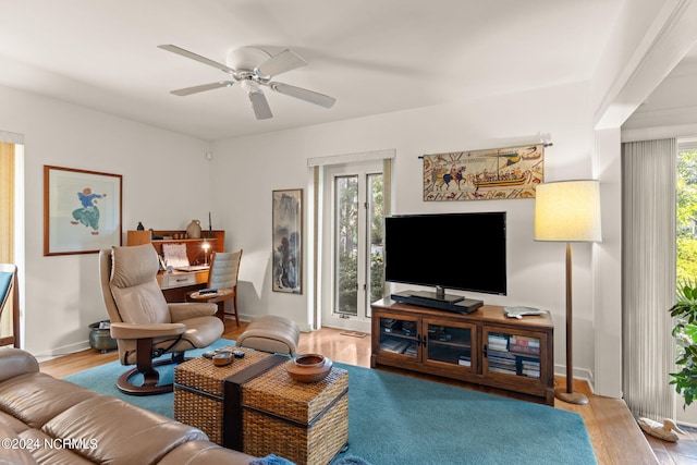 living room with light hardwood / wood-style flooring, ceiling fan, and plenty of natural light