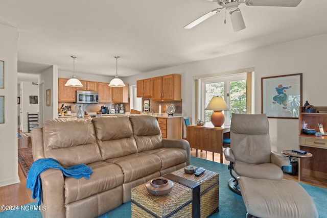 living room with light hardwood / wood-style floors and ceiling fan