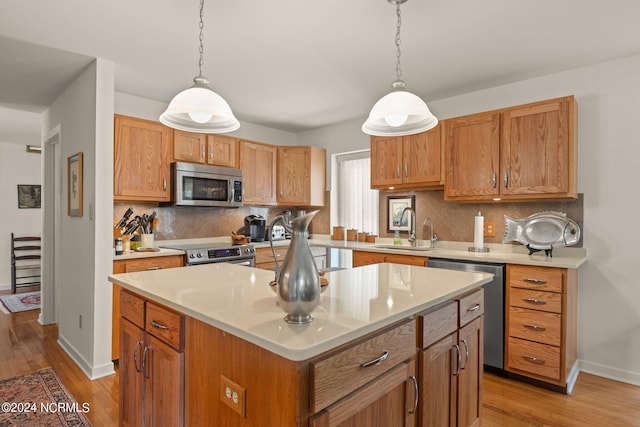 kitchen with stainless steel appliances, backsplash, a center island, and light wood-type flooring