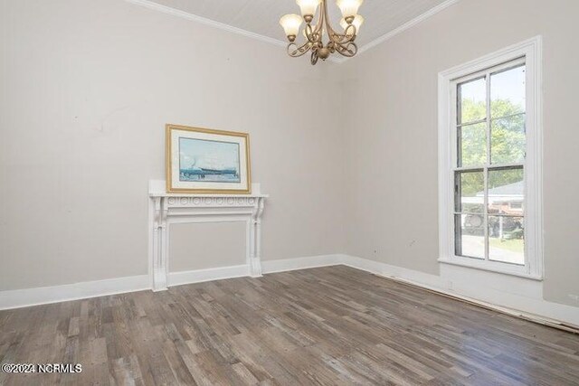 unfurnished room featuring crown molding, dark wood-type flooring, and an inviting chandelier