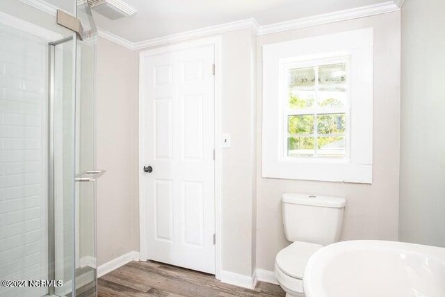 bathroom with toilet, a shower with door, hardwood / wood-style flooring, and ornamental molding