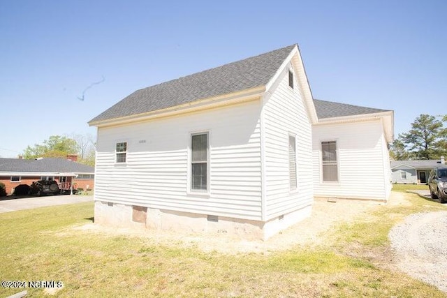 view of property exterior with crawl space, a shingled roof, and a yard