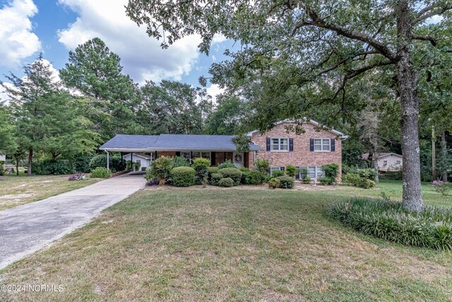 tri-level home with a front lawn and a carport