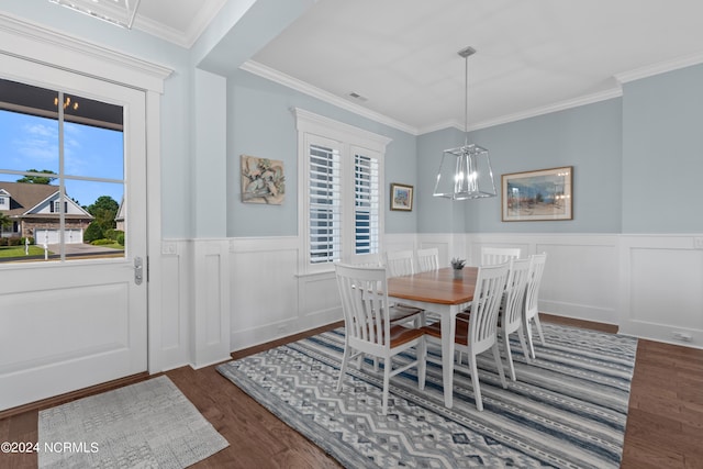 dining room featuring a chandelier, a wainscoted wall, wood finished floors, and crown molding