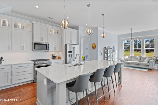 kitchen with visible vents, dark wood finished floors, appliances with stainless steel finishes, crown molding, and a sink