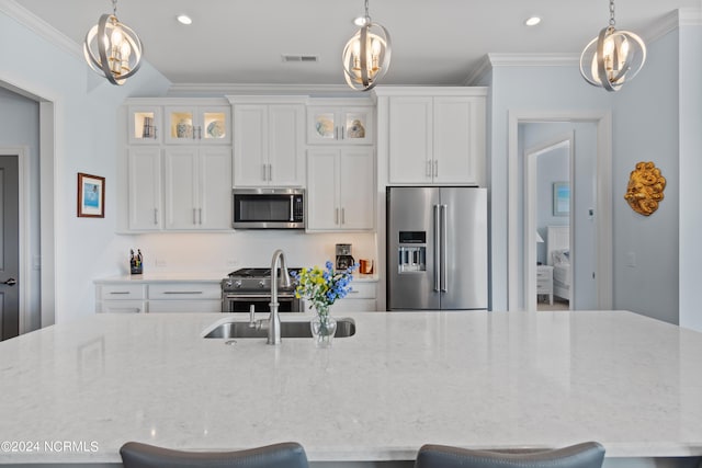 kitchen with visible vents, stainless steel appliances, a sink, and ornamental molding