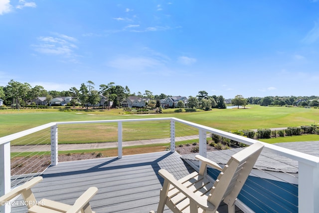 wooden deck with view of golf course and a yard