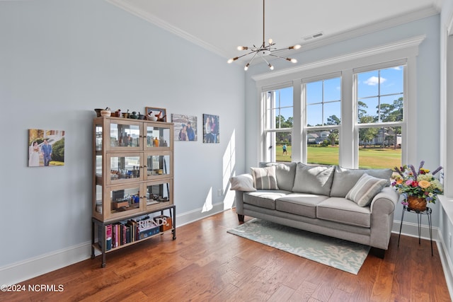 living area featuring baseboards, visible vents, wood finished floors, an inviting chandelier, and crown molding