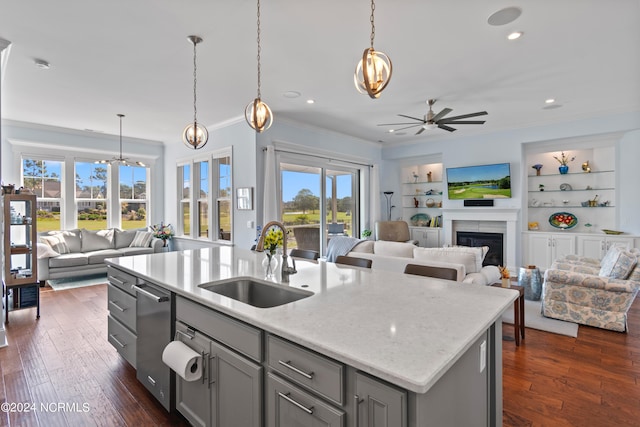 kitchen featuring open floor plan, gray cabinets, a fireplace, and a sink