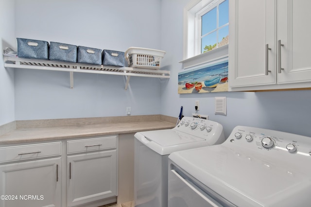 clothes washing area with washer and dryer and cabinet space