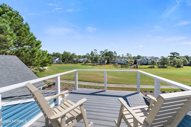 wooden terrace with a residential view and a lawn