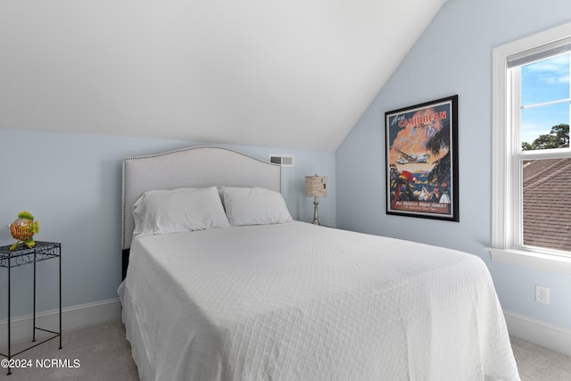 carpeted bedroom with visible vents, vaulted ceiling, and baseboards