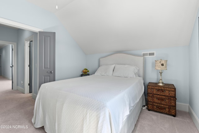 bedroom with light carpet, lofted ceiling, visible vents, and baseboards