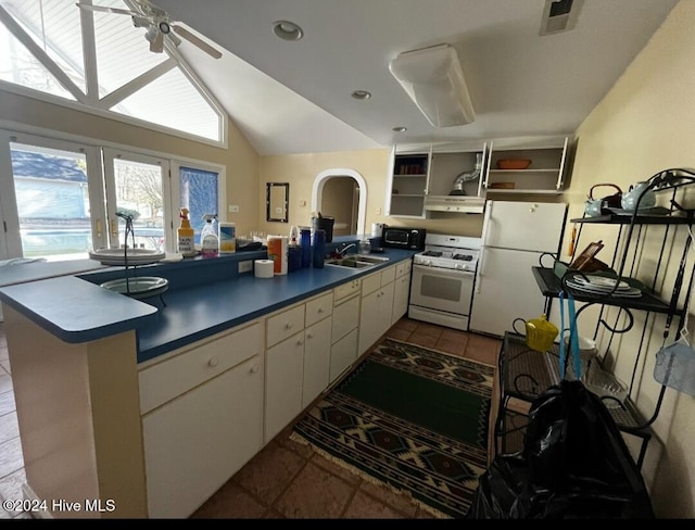 kitchen featuring open shelves, visible vents, a sink, white appliances, and a peninsula