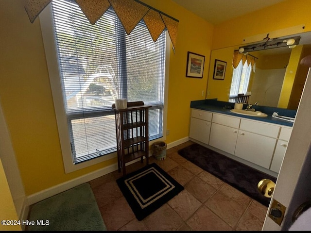 bathroom with tile patterned floors, baseboards, and vanity