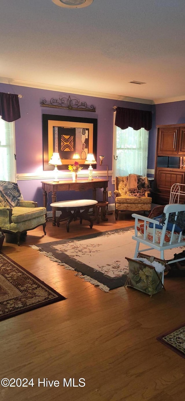 living room featuring crown molding and hardwood / wood-style flooring