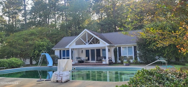 back of house featuring a patio area, an outbuilding, an outdoor pool, and an exterior structure