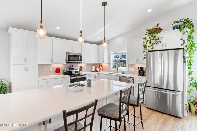 kitchen with stainless steel appliances, a breakfast bar area, backsplash, and a sink