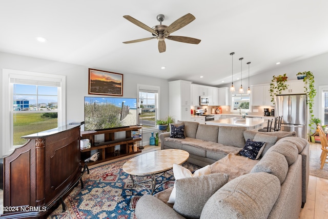 living area featuring light wood-style floors, ceiling fan, vaulted ceiling, and recessed lighting