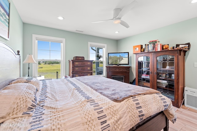 bedroom featuring a ceiling fan, light wood-type flooring, multiple windows, and recessed lighting