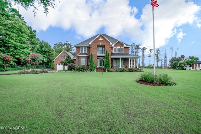 view of front facade featuring a front yard and covered porch