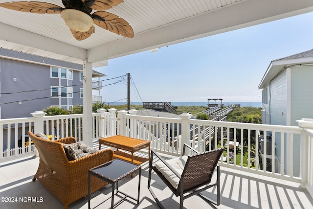 balcony with ceiling fan and a water view