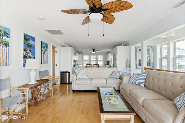 living room with ceiling fan, light hardwood / wood-style floors, and crown molding