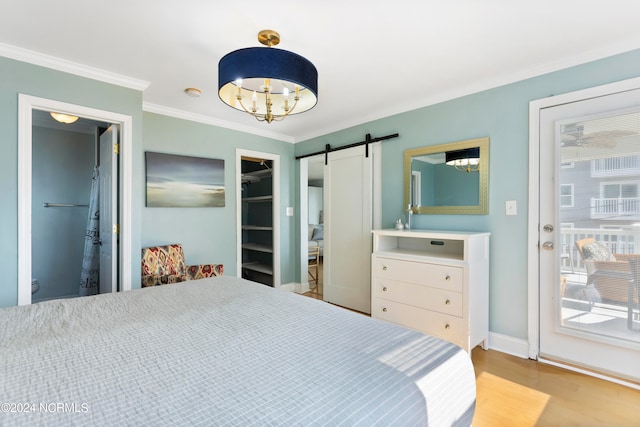 bedroom with a barn door, light wood-type flooring, and ornamental molding