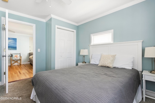 bedroom with carpet, ceiling fan, ornamental molding, and a closet