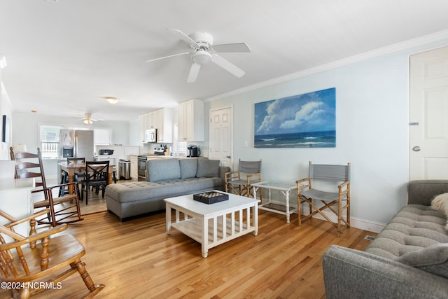 living room with ceiling fan, ornamental molding, and light wood-type flooring