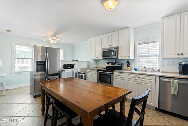 kitchen featuring white cabinets, plenty of natural light, stainless steel appliances, and ceiling fan