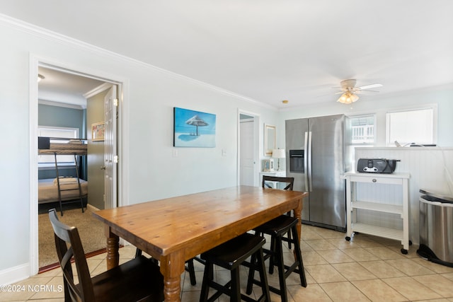 tiled dining space with crown molding and ceiling fan