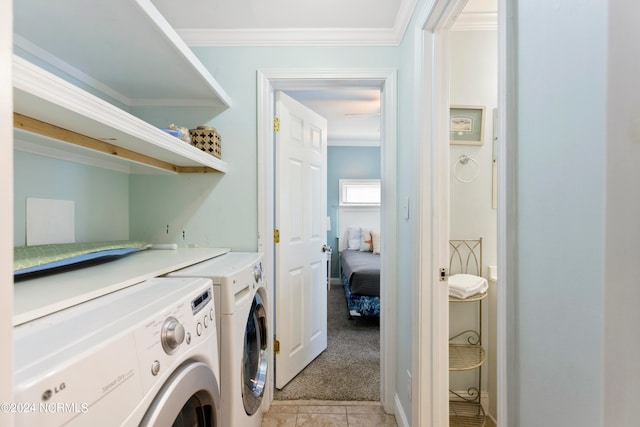 laundry area featuring washer and clothes dryer, ornamental molding, and light tile patterned floors